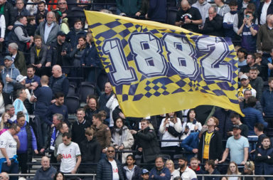 Spurs fans wave a giant flag at the Tottenham Hotspur Stadium